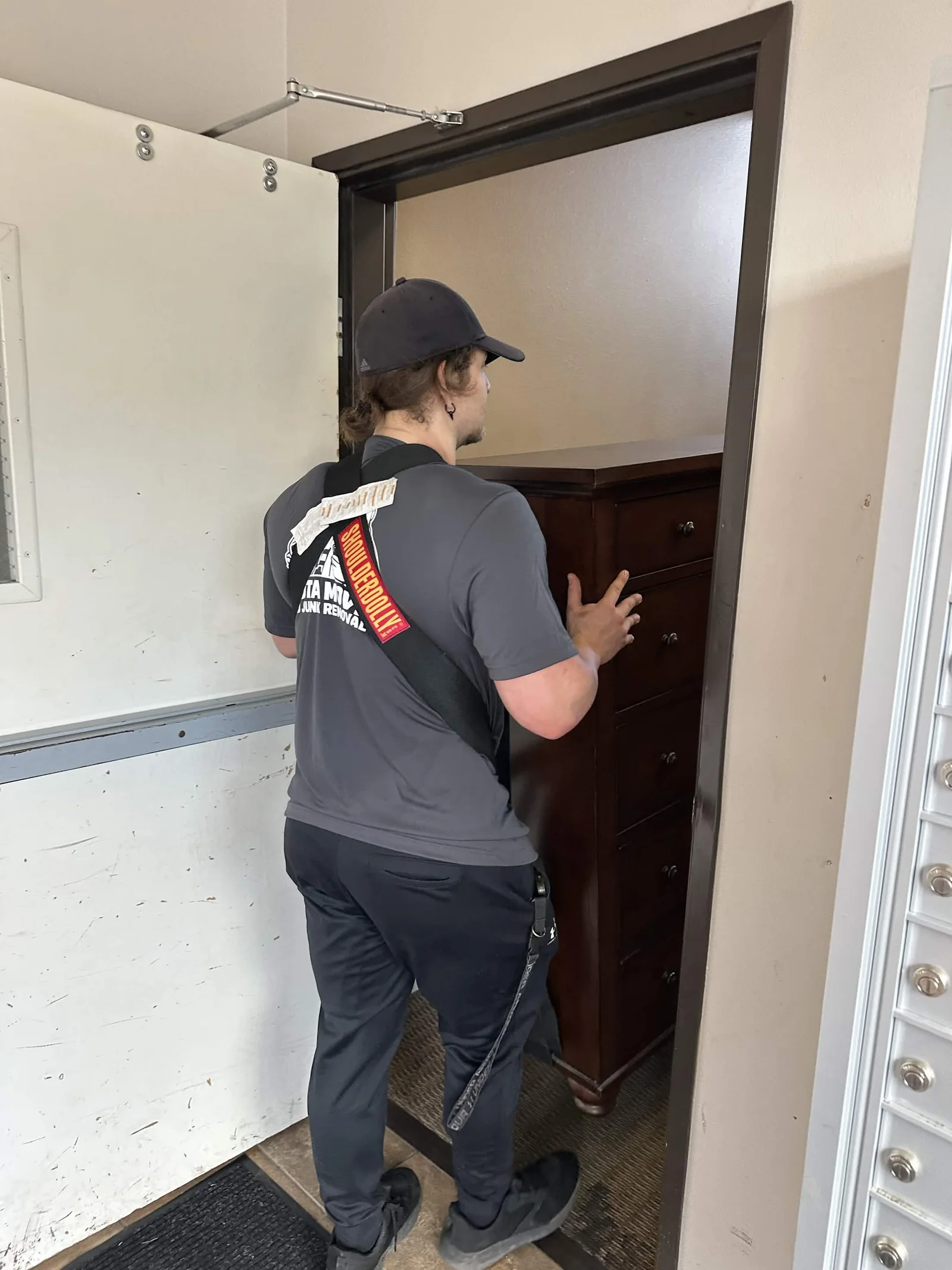 A Dakota mover guiding a dresser through a doorway.
